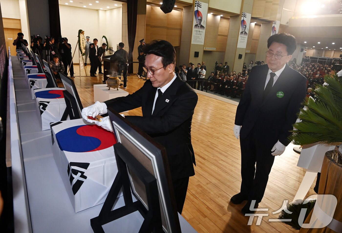 본문 이미지 - 김민석 국무총리가 13일 오전 서울 동작구 현충원 현충관에서 거행된 광복 80년 만에 고국으로 돌아온 미국과 브라질, 캐나다 안장 독립유공자 6명에 대한 유해 봉환식에서 건국훈장을 헌정하고 있다.  2025.8.13/뉴스1 ⓒ News1 청사사진기자단