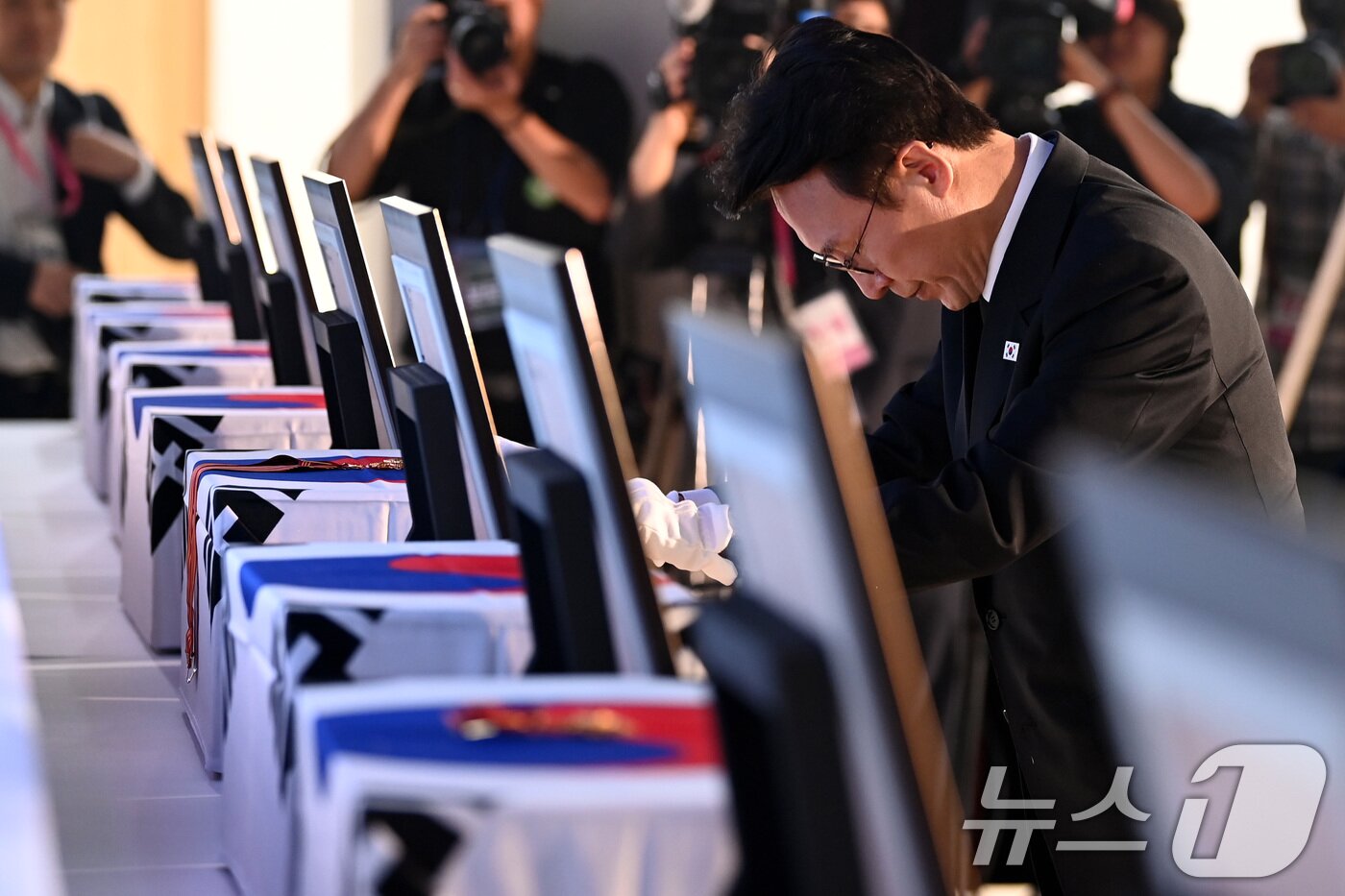 본문 이미지 - 김민석 국무총리가 13일 오전 서울 동작구 현충원 현충관에서 거행된 광복 80년 만에 고국으로 돌아온 미국과 브라질, 캐나다 안장 독립유공자 6명에 대한 유해 봉환식에서 건국훈장을 헌정하고 있다. 2025.8.13/뉴스1 ⓒ News1 청사사진기자단