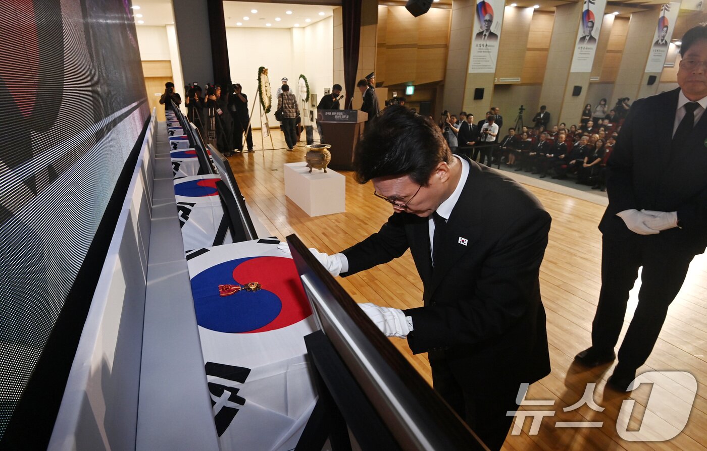 본문 이미지 - 김민석 국무총리가 13일 오전 서울 동작구 현충원 현충관에서 거행된 광복 80년 만에 고국으로 돌아온 미국과 브라질, 캐나다 안장 독립유공자 6명에 대한 유해 봉환식에서 건국훈장을 헌정하고 있다. 2025.8.13/뉴스1 ⓒ News1 청사사진기자단