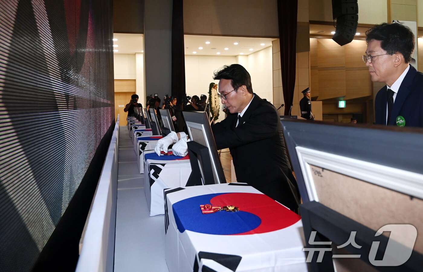 본문 이미지 - 김민석 국무총리가 13일 오전 서울 동작구 현충원 현충관에서 거행된 광복 80년 만에 고국으로 돌아온 미국과 브라질, 캐나다 안장 독립유공자 6명에 대한 유해 봉환식에서 건국훈장을 헌정하고 있다. 2025.8.13/뉴스1 ⓒ News1 청사사진기자단