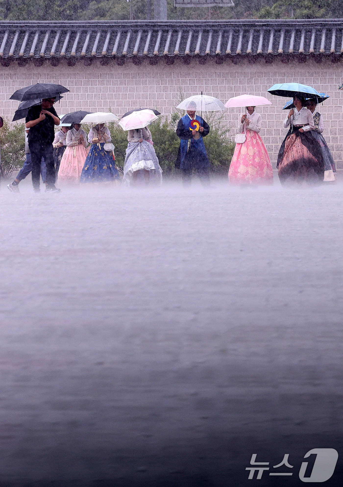 (서울=뉴스1) 박지혜 기자 = 호우특보가 발효된 13일 서울 종로구 국립고궁박물관 인근에서 외국인 관광객들이 우산을 쓴 채 발걸음을 옮기고 있다. 2025.8.13/뉴스1