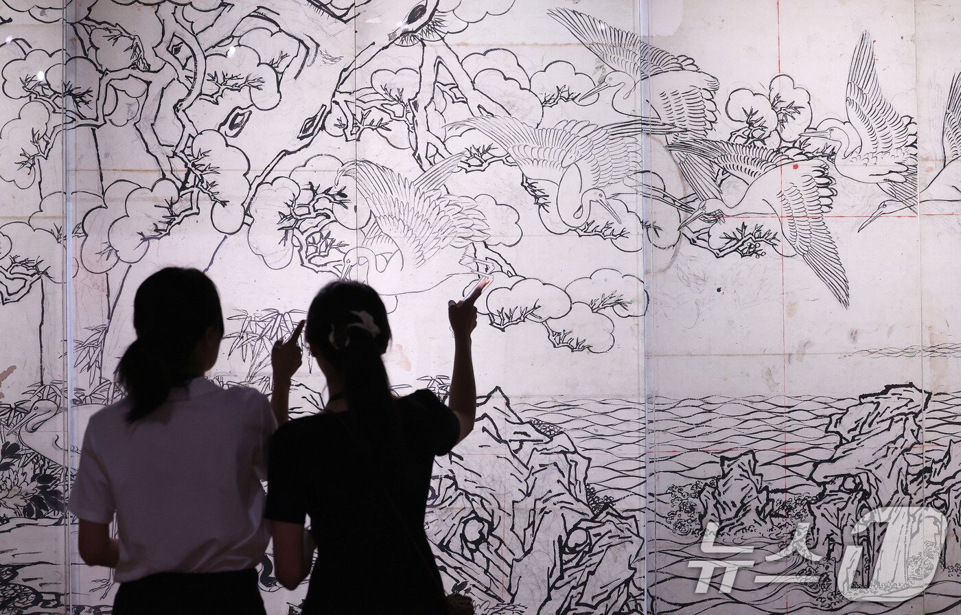 본문 이미지 - 13일 서울 종로구 국립고궁박물관 2층 기획전시실에서 열린 특별전 '창덕궁의 근사謹寫한 벽화' 언론 공개회에서 참석자들이 최초 공개된 김은호의 백학도 초본(정본을 완성하기 전 그린 밑그림)을 살펴보고 있다. 국립고궁박물관은 14일부터 개관 20주년 특별전 '창덕궁의 근사謹寫한 벽화'에서 창덕궁 내전인 희정당, 대조전, 경훈각을 장식했던 벽화 6점을 최초로 일괄 공개한다. 2025.8.13/뉴스1 ⓒ News1 박지혜 기자