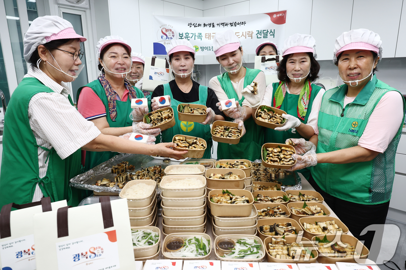 (서울=뉴스1) 김민지 기자 = 13일 서울 송파구 방이1동주민센터에서 새마을 부녀회 관계자들이 보훈가족 어르신들과 홀몸 어르신 등에게 전달할 장어 도시락과 태극 문양 떡을 담은 …