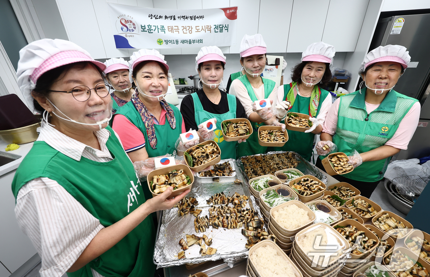 (서울=뉴스1) 김민지 기자 = 13일 서울 송파구 방이1동주민센터에서 새마을 부녀회 관계자들이 보훈가족 어르신들과 홀몸 어르신 등에게 전달할 장어 도시락과 태극 문양 떡을 담은 …