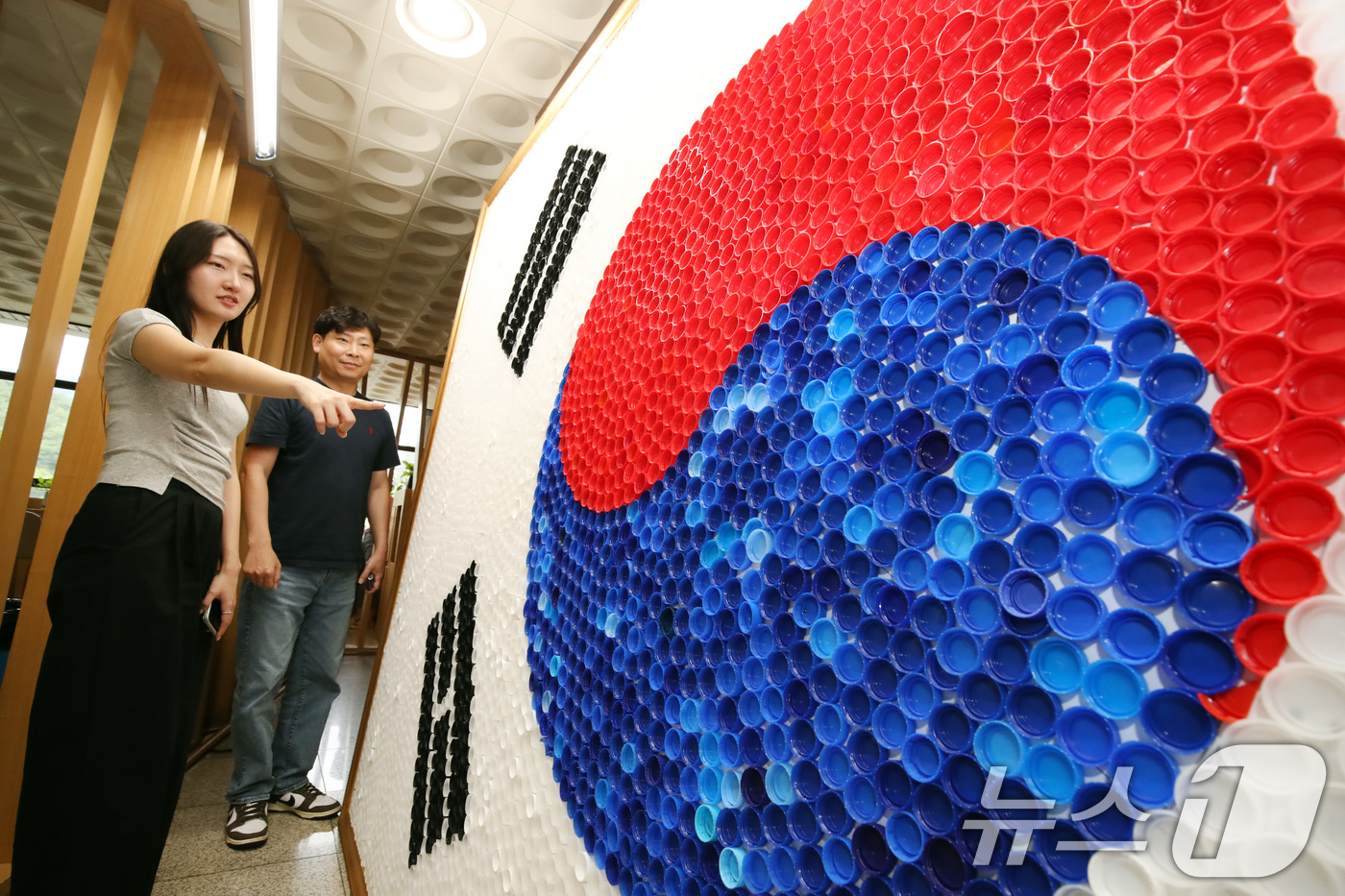 (대구=뉴스1) 공정식 기자 = 80주년 광복절을 이틀 앞둔 13일 대구 달서구청 로비에 달서구노인종합복지관 어르신들이 페트병 뚜껑 6900여 개를 붙여 만든 '생명의 태극기'가 …