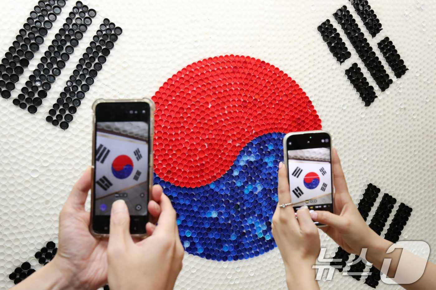 (대구=뉴스1) 공정식 기자 = 80주년 광복절을 이틀 앞둔 13일 대구 달서구청 로비에 달서구노인종합복지관 어르신들이 페트병 뚜껑 6900여 개를 붙여 만든 '생명의 태극기'가 …