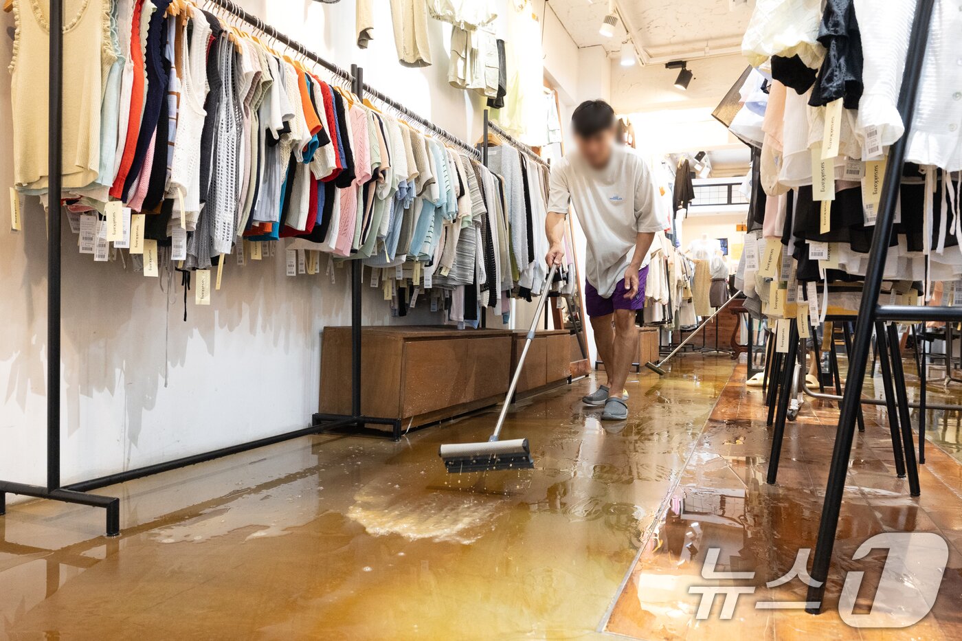 본문 이미지 - 13일 오후 서울 은평구 연신내역 인근 옷가게에 폭우로 물이 넘쳐와 상인이 가게를 청소하고 있다. 2025.8.13/뉴스1 ⓒ News1 이승배 기자