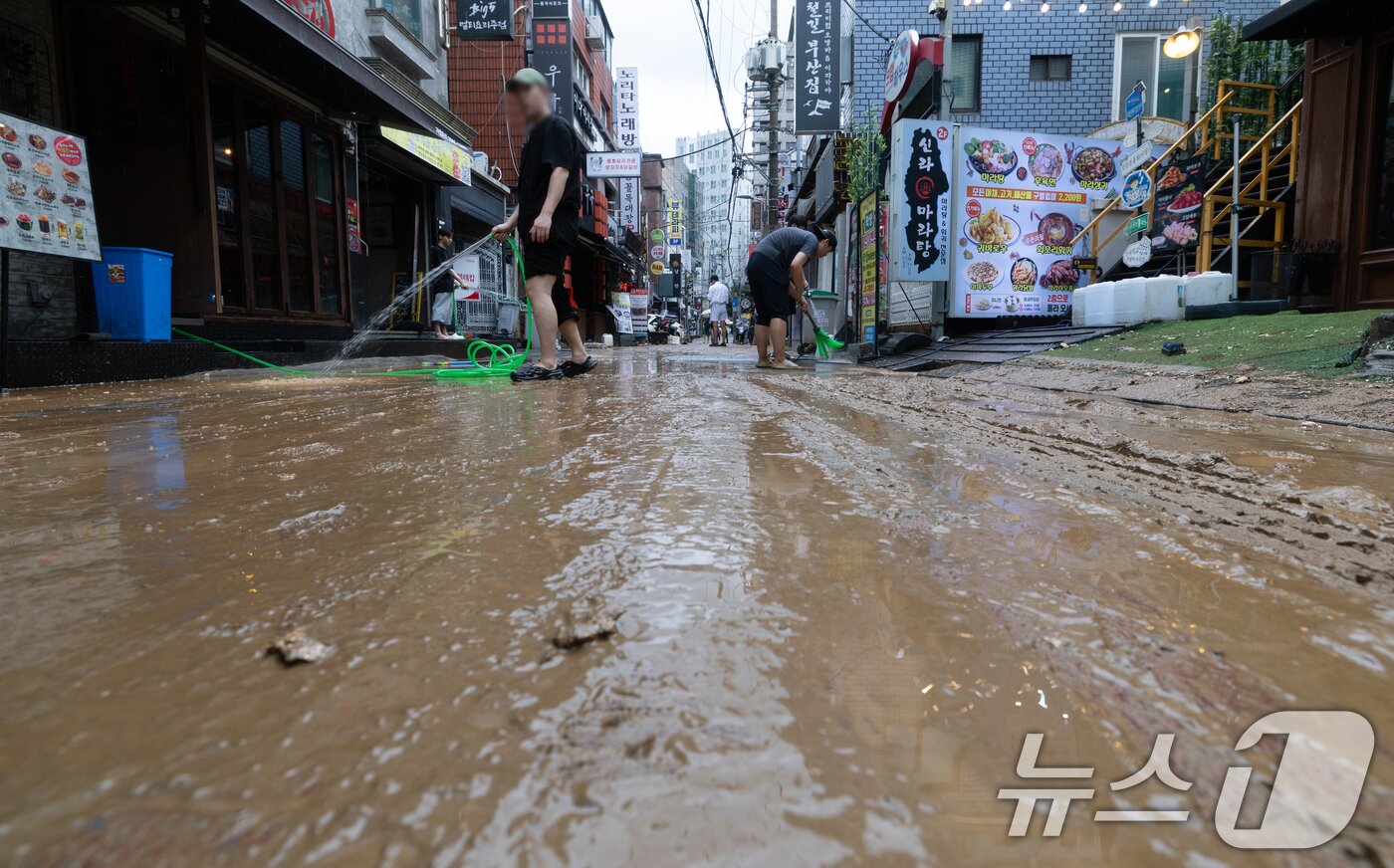 본문 이미지 - 13일 오후 서울 은평구 연신내역 인근 상가 거리에서 상인들이 폭우로 인해 더러워진 거리를 청소하고 있다. 2025.8.13/뉴스1 ⓒ News1 이승배 기자