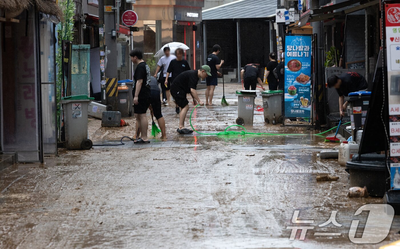 본문 이미지 - 13일 오후 서울 은평구 연신내역 인근 상가 거리에서 상인들이 폭우로 인해 더러워진 거리를 청소하고 있다. 2025.8.13/뉴스1 ⓒ News1 이승배 기자