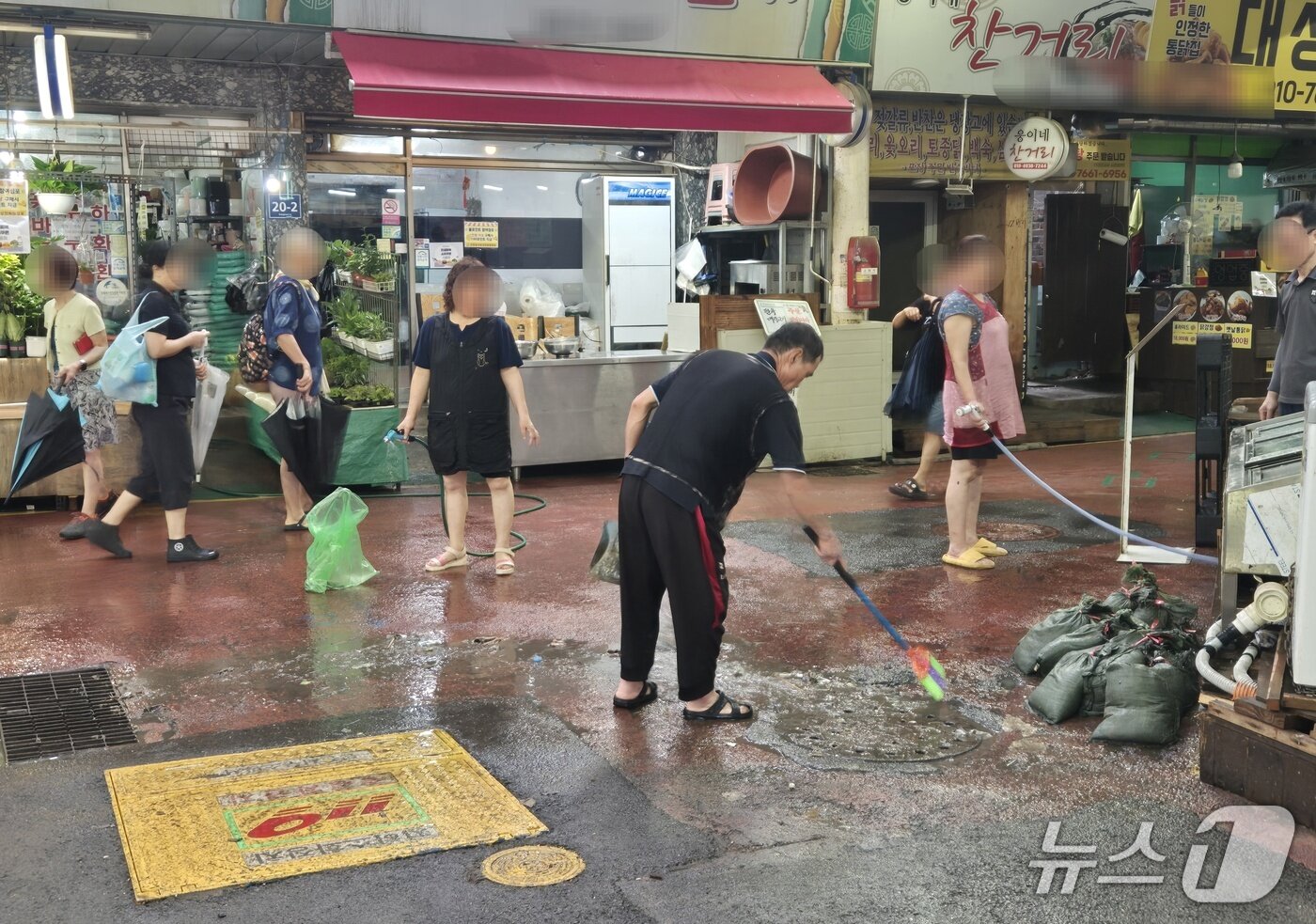 본문 이미지 - 13일 오후 2시30분쯤 찾은 인천 서구 강남시장 상인들이 거리에 나와 쌓인 흙과 쓰레기들을 치우고 있다.이시명 기자/뉴스1