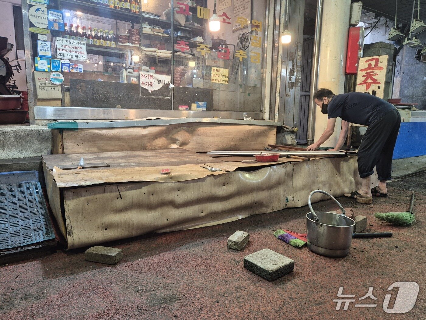 본문 이미지 - E 씨가 진열대를 줄자로 측정하고 있다.이시명기자/뉴스1