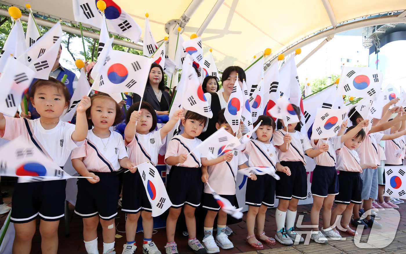 (대구=뉴스1) 공정식 기자 = 80주년 광복절을 하루 앞둔 14일 오전 대구 동구 큰고개오거리에서 한국자유총연맹 대구동구지회 회원과 동문어린이집 원아들이 '나라사랑 태극기 달기 …