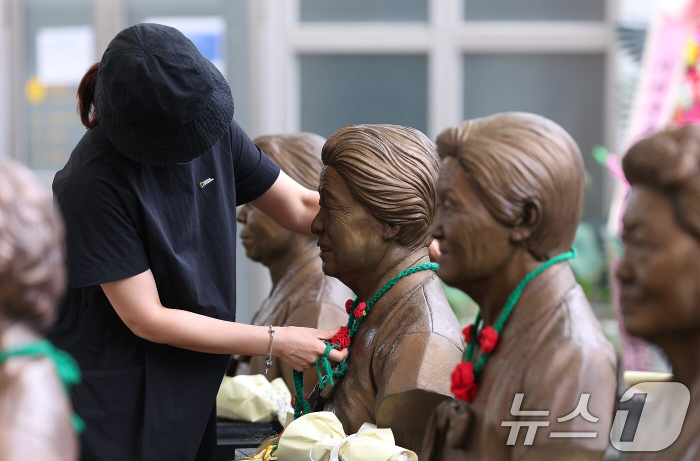본문 이미지 - &#39;일본군 위안부 피해자 기림의 날&#39;인 14일 경기 광주시 퇴촌면 나눔의집에서 한 시민이 위안부 피해자 할머니들의 흉상에 직접 뜨개질한  ⓒ News1 김영운 기자