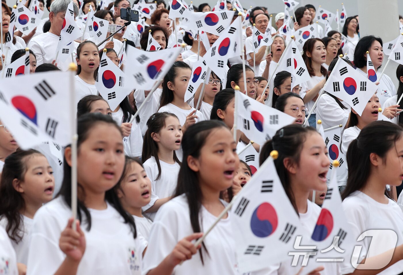 본문 이미지 - 14일 서울 송파구 서울놀이마당에서 열린 제80주년 광복절 기념 &#39;송파구민 대합창&#39;에서 어린이 합창단을 비롯한 참가자들이 태극기를 흔들며 대한민국 만세 삼창을 하고 있다. 2025.8.14/뉴스1 ⓒ News1 김성진 기자
