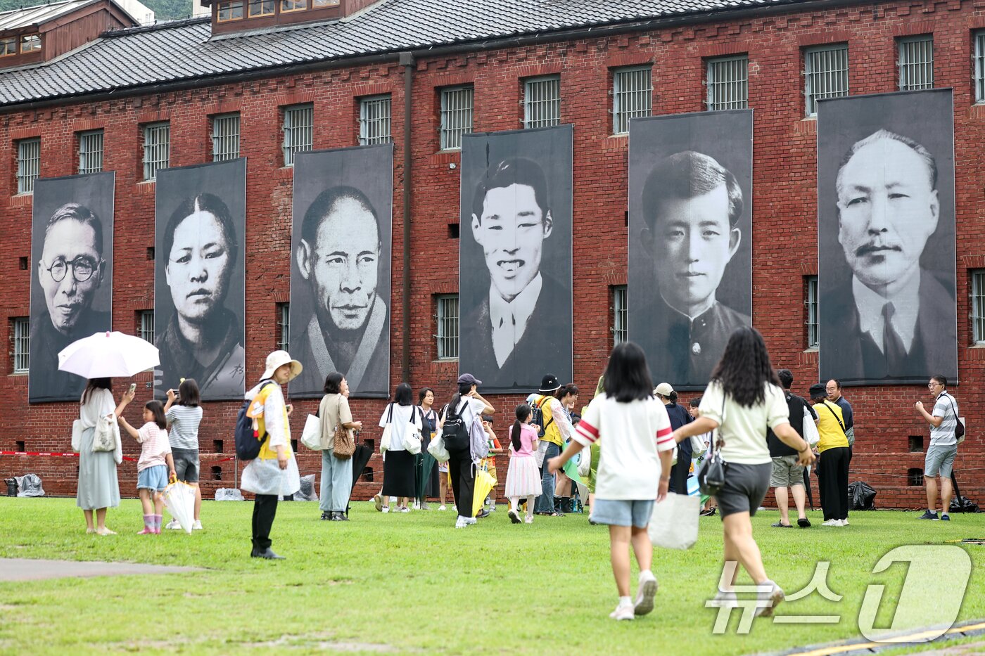 본문 이미지 - 제80주년 광복절을 하루 앞둔 14일 서울 서대문형무소역사관에 독립운동가들의 모습을 담은 현수막과 태극기가 걸려 있다. 2025.8.14/뉴스1 ⓒ News1 민경석 기자