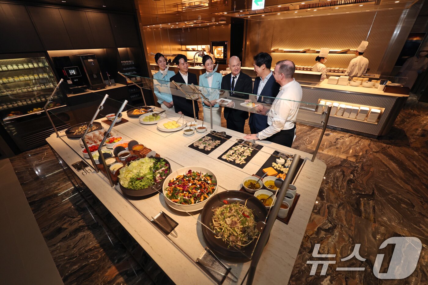본문 이미지 - 데이비드 페이시 기내식기판 및 라운지부문 부사장(오른쪽 세 번째)이 14일 인천국제공항 제2터미널 대한항공 마일러클럽에서 열린 신규라운지 오픈 행사에서 '라이브 스테이션'을 체험하고 있다.(공동취재) 2025.8.14/뉴스1 ⓒ News1 박지혜 기자