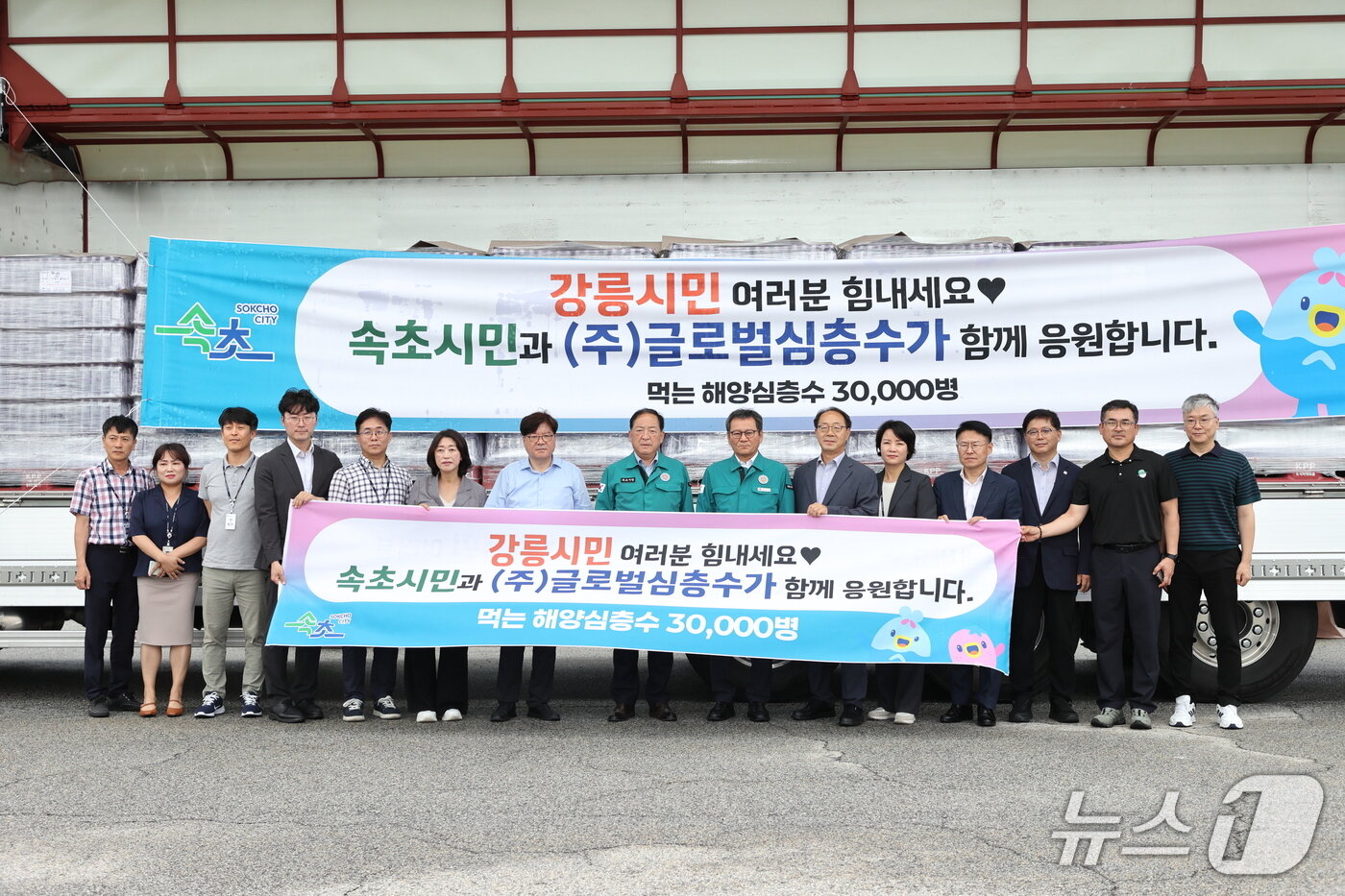 본문 이미지 - 14일 김홍규 강릉시장과 이병선 속초시장, 김진규 글로벌심층수 대표, 두 지자체 간부공무원들이 속초시가 지원한 생수 앞에서 기념촬영을 하고 있다.&#40;강릉시 제공, 재판매 및 DB 금지&#41; 2025.8.14/뉴스1