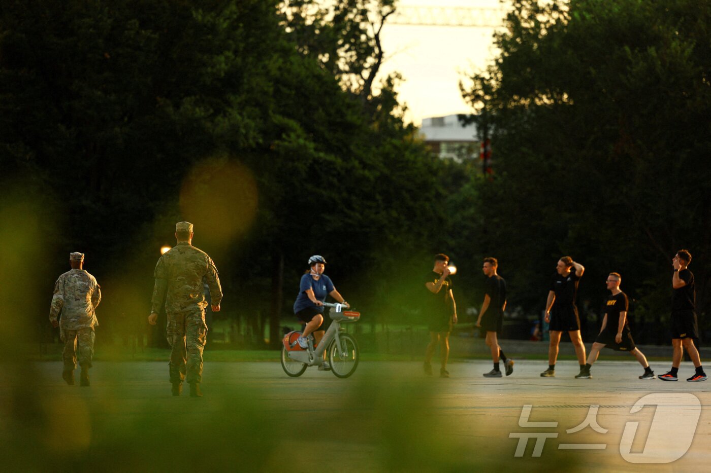 본문 이미지 - 미국 군인들이 14일 워싱턴DC의 한 거리에서 운동하는 사람들 근처를 지나가고 있다. 도널드 트럼프 미국 대통령은 워싱턴DC 메트로폴리탄 경찰청의 연방 관할권을 발표하고, 수도의 범죄 예방을 돕는다는 명목으로 주 방위군을 배치했다. 2025.8.14 ⓒ 로이터=뉴스1 ⓒ News1 강민경 기자