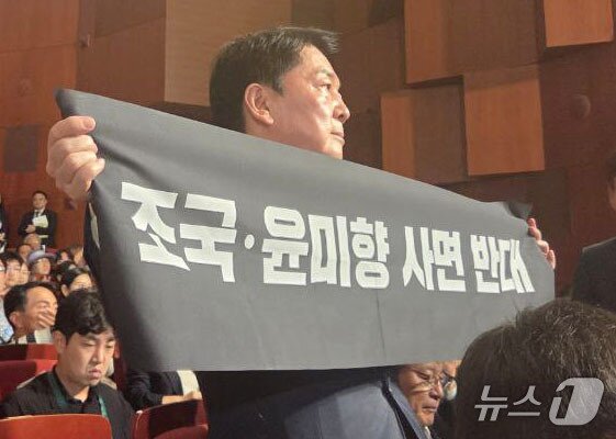 본문 이미지 - 안철수 국민의힘 당대표 후보가 15일 오전 서울 종로구 세종문화회관에서 열린 제80주년 광복절 경축식에 참석해 경축사 중인 이재명 대통령을 향해 조국 전 조국혁신당 대표와 윤미향 전 의원의 사면 반대 플래카드를 들어보이며 항의하고 있다. &#40;안철수 캠프 제공&#41; 2025.8.15/뉴스1