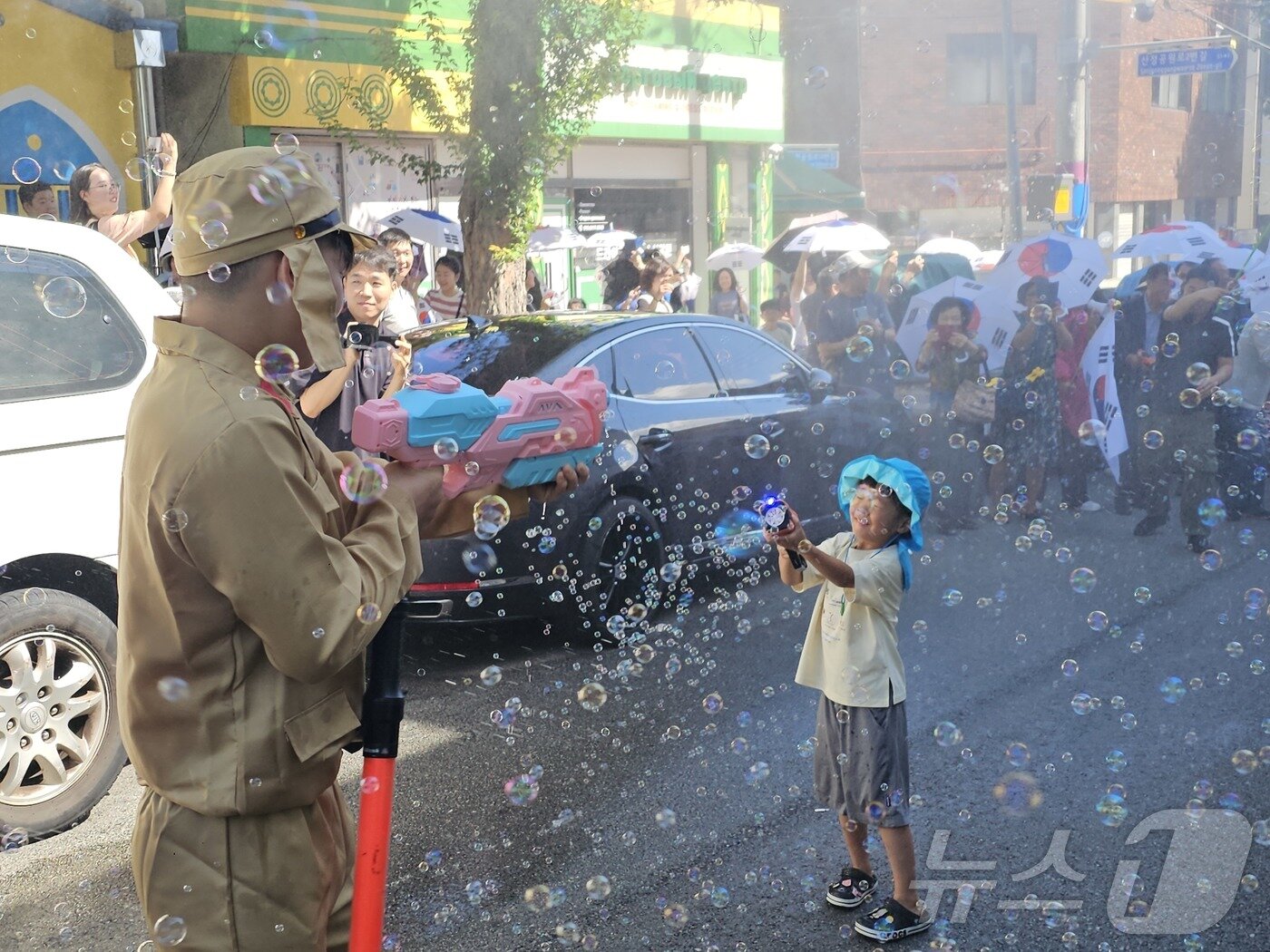 본문 이미지 - 제80주년 광복절인 15일 광주 광산구 월곡동 고려인마을에서 봉오동전투 재현 행사가 열린 가운데 독립군 어린이와 일본군 청소년이 비눗방울총을 서로에게 뿌리고 있다. ⓒ News1 서충섭 기자
