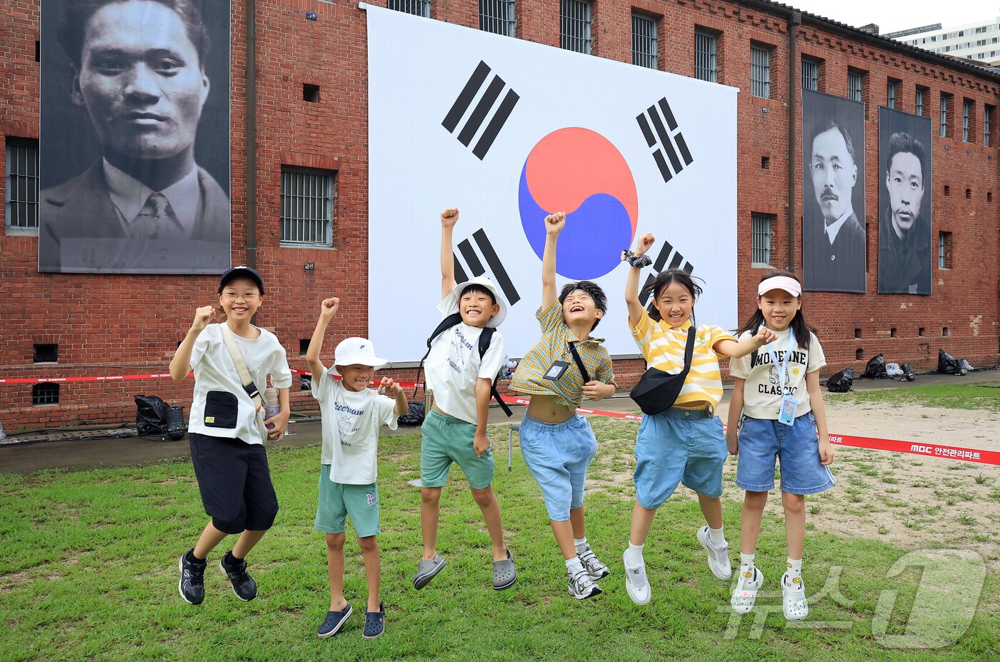 본문 이미지 - 제80주년 광복절인 15일 서울 서대문형무소역사관을 찾은 어린이들이 대형 태극기와 독립운동가들의 얼굴이 담긴 현수막 앞에서 &#39;대한독립만세&#39;를 외치고 있다. 2025.8.15/뉴스1 ⓒ News1 김진환 기자
