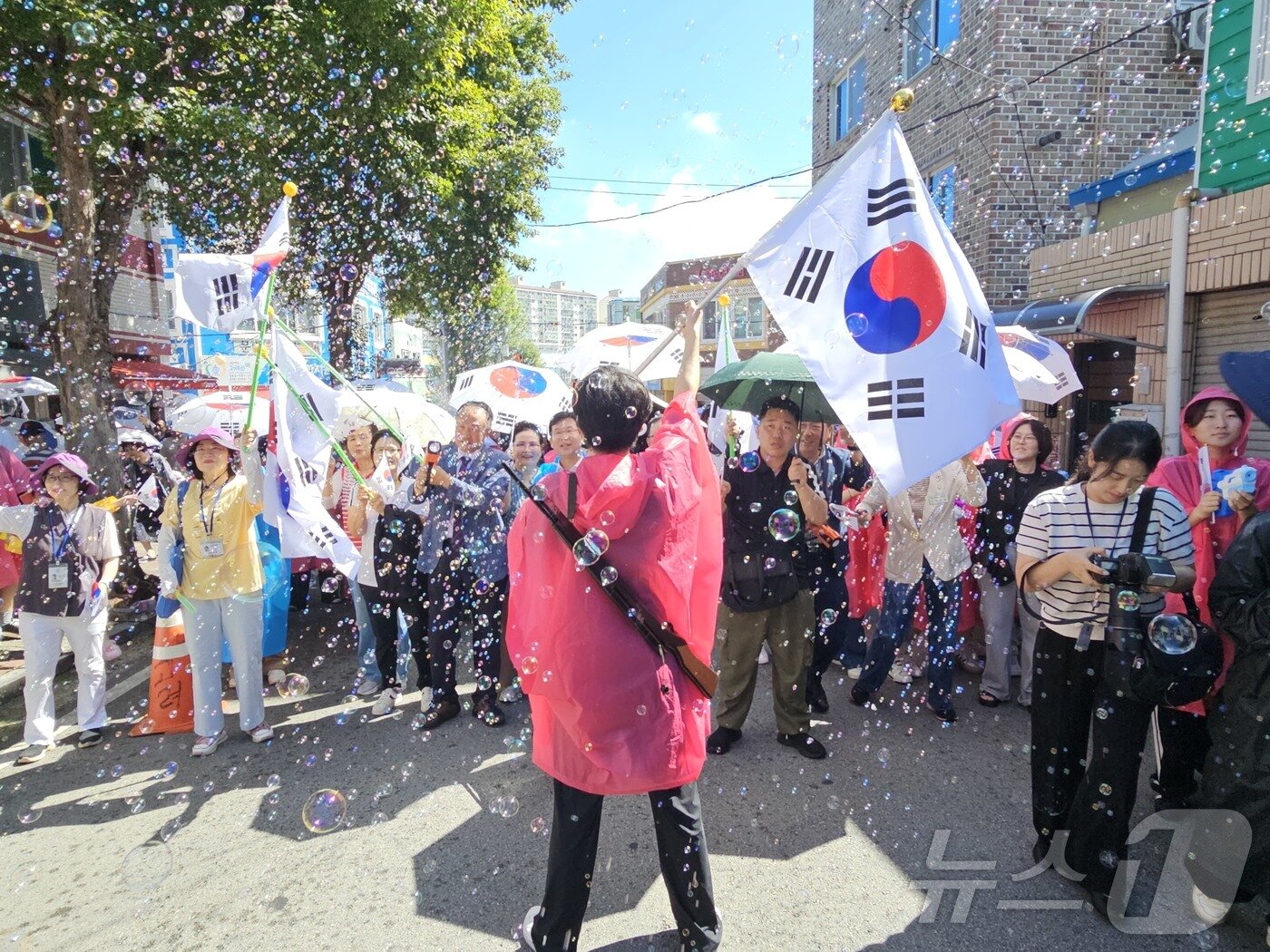 본문 이미지 - 제80주년 광복절인 15일 오전 광주 광산구 월곡동 고려인마을에서 봉오동전투 재현 비눗방울축제가 열린 가운데 태극기를 든 독립군 대장 역할 진행자가 대한독립만세를 외치고 있다. 2025.8.15/뉴스1 ⓒ News1 서충섭 기자