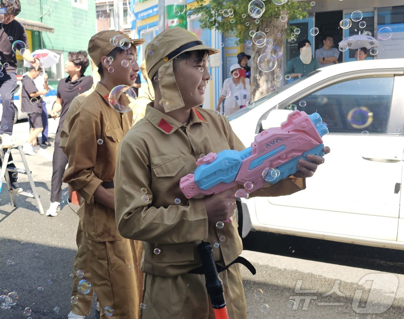 (광주=뉴스1) 서충섭 기자 = 제80주년 광복절인 15일 광주 광산구 월곡동 고려인마을에서 봉오동전투 재현 행사가 열린 가운데 일본제국군 역할을 맡은 고려인 어린이가 비눗방울총을 …