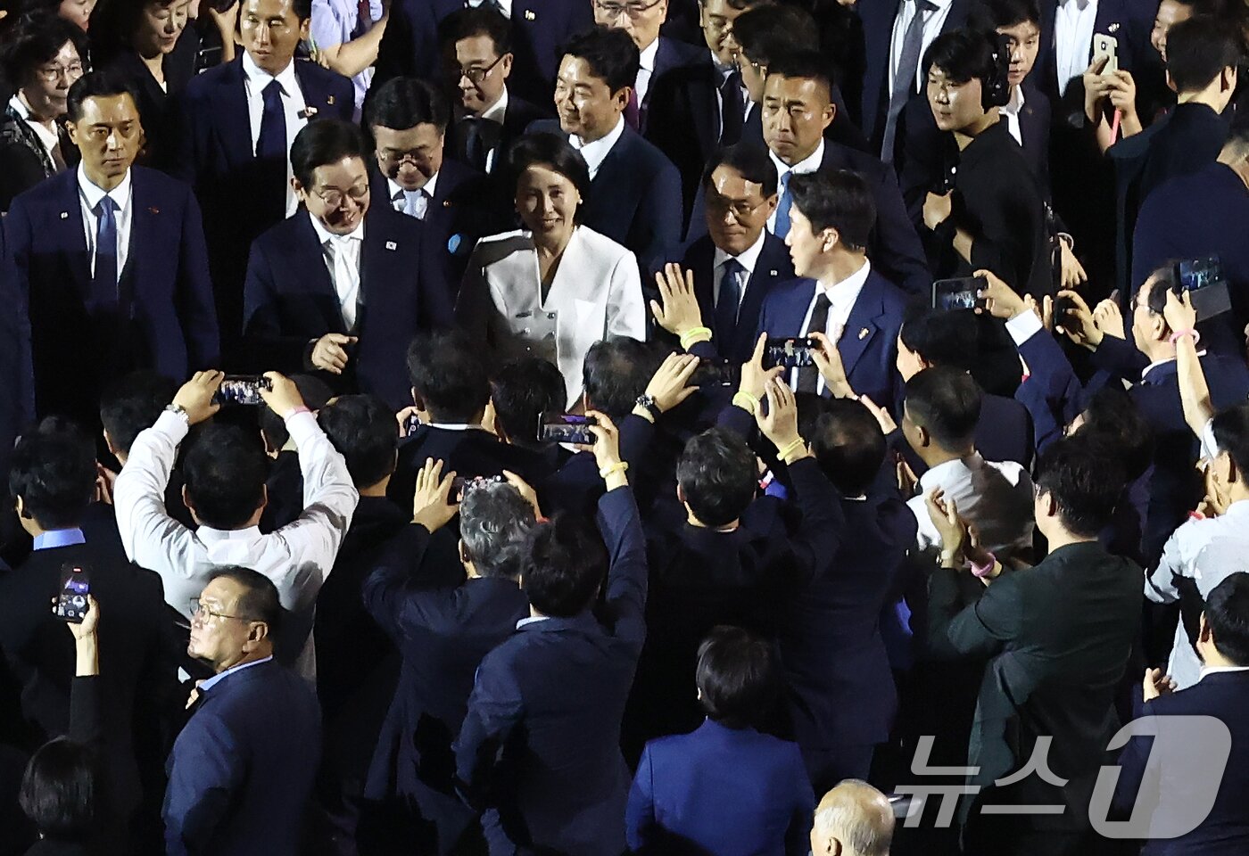 본문 이미지 - 이재명 대통령과 부인 김혜경 여사가 15일 오후 서울 종로구 광화문광장에서 열린 &#39;광복 80년, 국민 주권으로 미래를 세우다&#39; 제21대 대통령 국민 임명식에 입장하며 시민들을 향해 인사하고 있다. 2025.8.15/뉴스1 ⓒ News1 김민지 기자