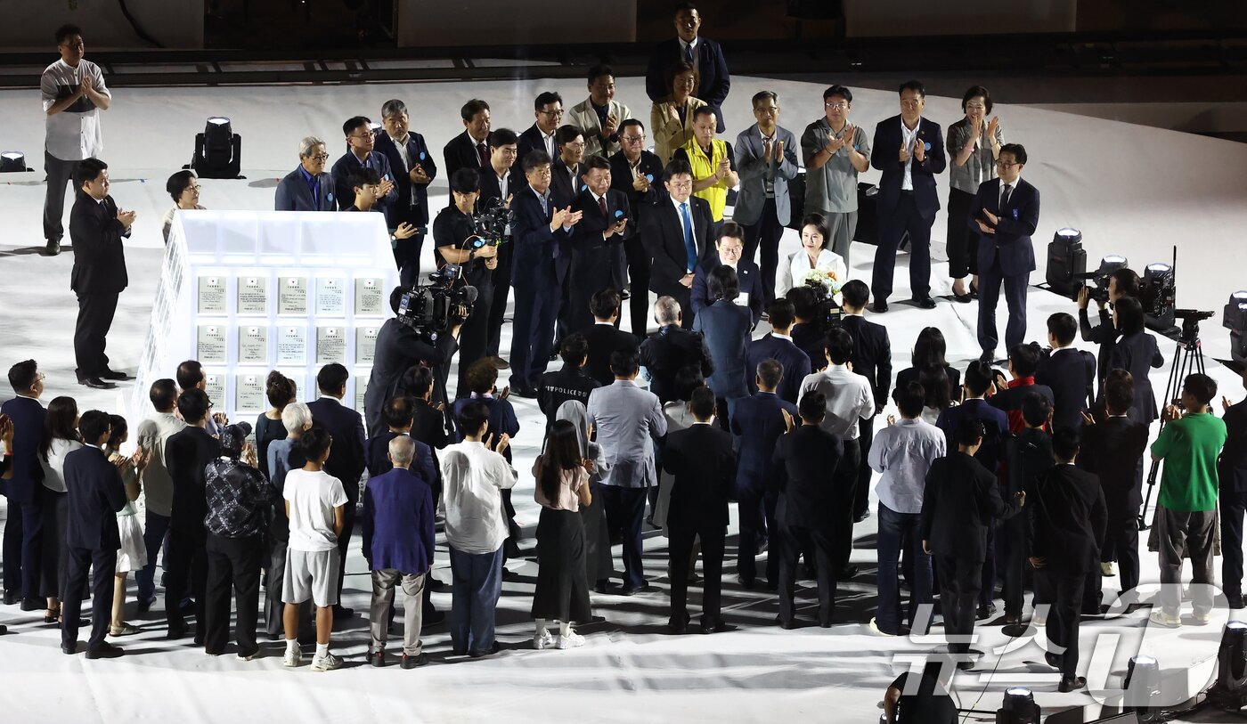 본문 이미지 - 이재명 대통령이 15일 오후 서울 종로구 광화문광장에서 열린 '광복 80년, 국민 주권으로 미래를 세우다' 제21대 대통령 국민 임명식에서 국민 대표 80인이 참여한 빛의 임명장을 전달 받고 있다. 2025.8.15/뉴스1 ⓒ News1 김민지 기자