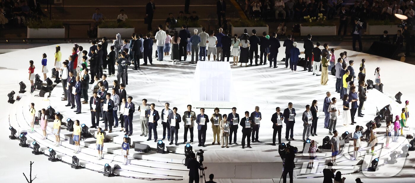 본문 이미지 - 15일 오후 서울 종로구 광화문광장에서 열린 &#39;광복 80년, 국민 주권으로 미래를 세우다&#39; 제21대 대통령 국민 임명식에서 국민 대표 80인이 &#39;이재명 대통령을 임명한다&#39;는 내용을 담은 빛의 임명장을 들어보이고 있다. 2025.8.15/뉴스1 ⓒ News1 김민지 기자