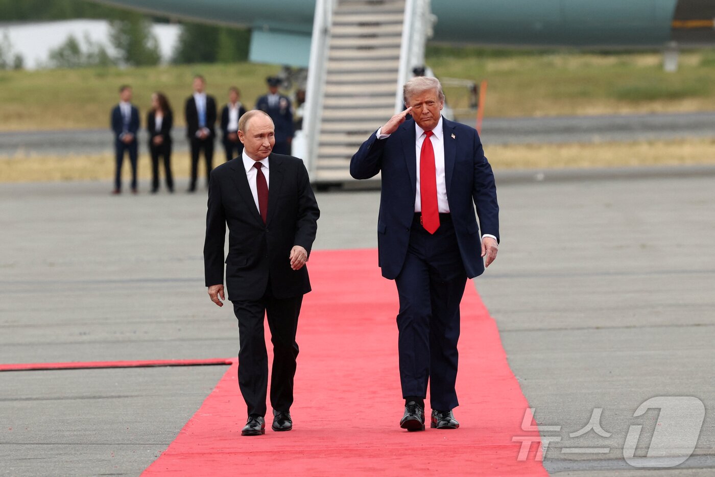 본문 이미지 - 도널드 트럼프 미국 대통령과 블라디미르 푸틴 러시아 대통령이 15일(현지시간) 미국 알래스카 앵커리지의 엘멘도르프-리처드슨 합동 기지 착륙장에서 만난 뒤 회담장 이동을 위해 나란히 걷고 있다. 거의 동시에 각자 전용기에 내려 만난 두 정상은 우크라이나 전쟁 종식을 위한 협상을 진행한다. 2025.08.15. ⓒ 로이터=뉴스1 ⓒ News1 류정민 특파원