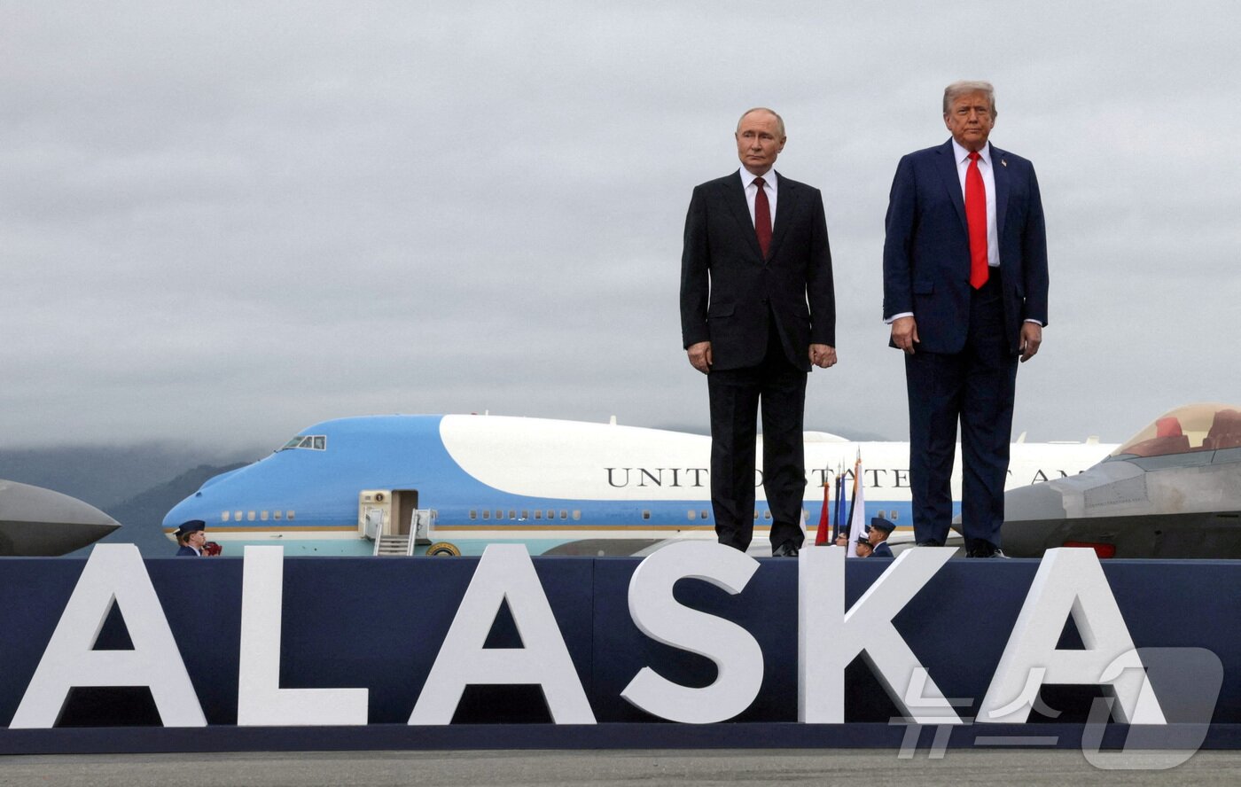 본문 이미지 - 도널드 트럼프 미국 대통령과 블라디미르 푸틴 러시아 대통령이 15일(현지시간) 미국 알래스카 앵커리지 엘멘도르프-리처드슨 합동 기지에서 열린 회담에 참석하기 위해 도착한 후 활주로 연단에서 포즈를 취하고 있다. 2025.8.15 ⓒ 로이터=뉴스1