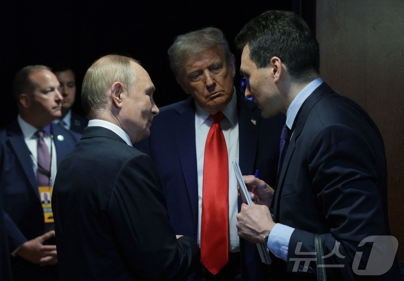 본문 이미지 - 도널드 트럼프 미국 대통령(가운데)이 15일 알래스카주 앵커리지의 엘먼도프-리처드슨 합동 기지에서 블라디미르 푸틴 러시아 대통령(왼쪽)과 통역을 사이에 두고 대화하고 있다. 2025.8.15 ⓒ AFP=뉴스1 ⓒ News1 강민경 기자
