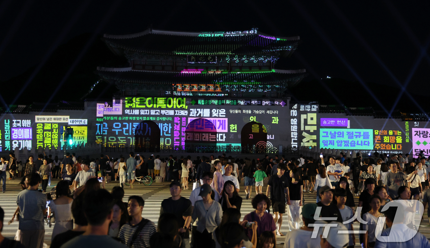 (서울=뉴스1) 김명섭 기자 = 16일 오후 서울 광화문 앞에서 시민들이 광복 80년 빛 축제 '80개의 빛, 하나된 우리' 미디어 파사드 영상을 보고 있다.이번 행사는 광화문과 …