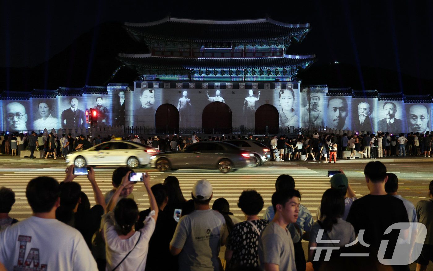 (서울=뉴스1) 김명섭 기자 = 16일 오후 서울 광화문 앞에서 시민들이 광복 80년 빛 축제 '80개의 빛, 하나된 우리'  미디어 파사드 영상을 보고 있다.이번 행사는 광화문과 …