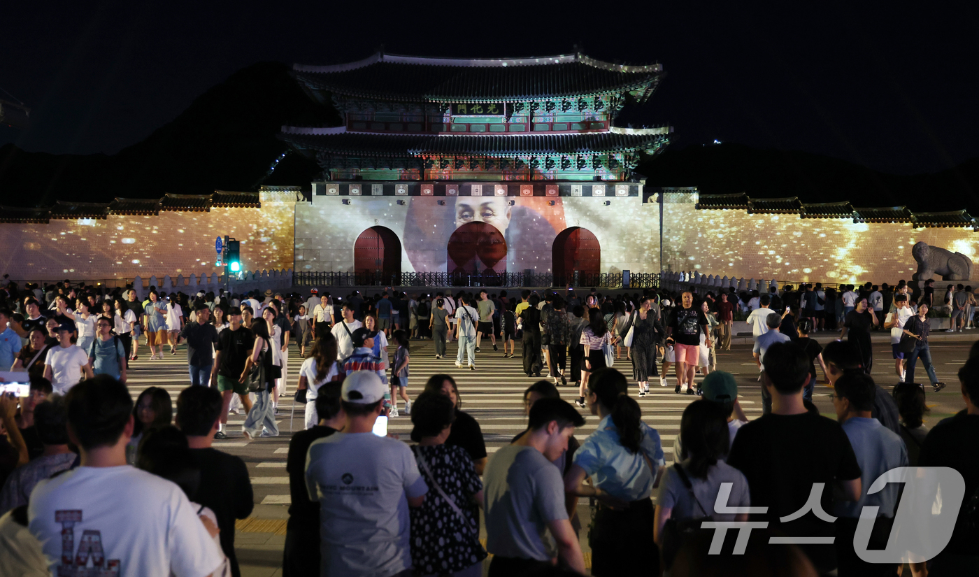 (서울=뉴스1) 김명섭 기자 = 16일 오후 서울 광화문 앞에서 시민들이 광복 80년 빛 축제 '80개의 빛, 하나된 우리' 미디어 파사드 영상을 보고 있다.이번 행사는 광화문과 …