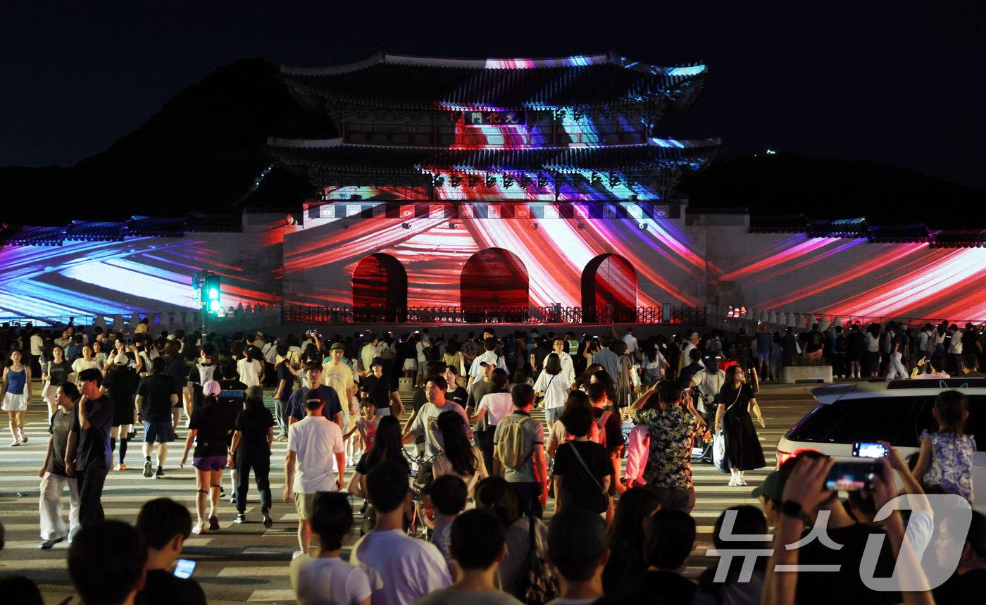 (서울=뉴스1) 김명섭 기자 = 16일 오후 서울 광화문 앞에서 시민들이 광복 80년 빛 축제 '80개의 빛, 하나된 우리' 미디어 파사드 영상을 보고 있다.이번 행사는 광화문과 …