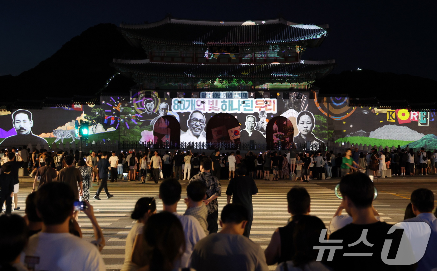(서울=뉴스1) 김명섭 기자 = 16일 오후 서울 광화문 앞에서 시민들이 광복 80년 빛 축제 '80개의 빛, 하나된 우리' 미디어 파사드 영상을 보고 있다.이번 행사는 광화문과 …