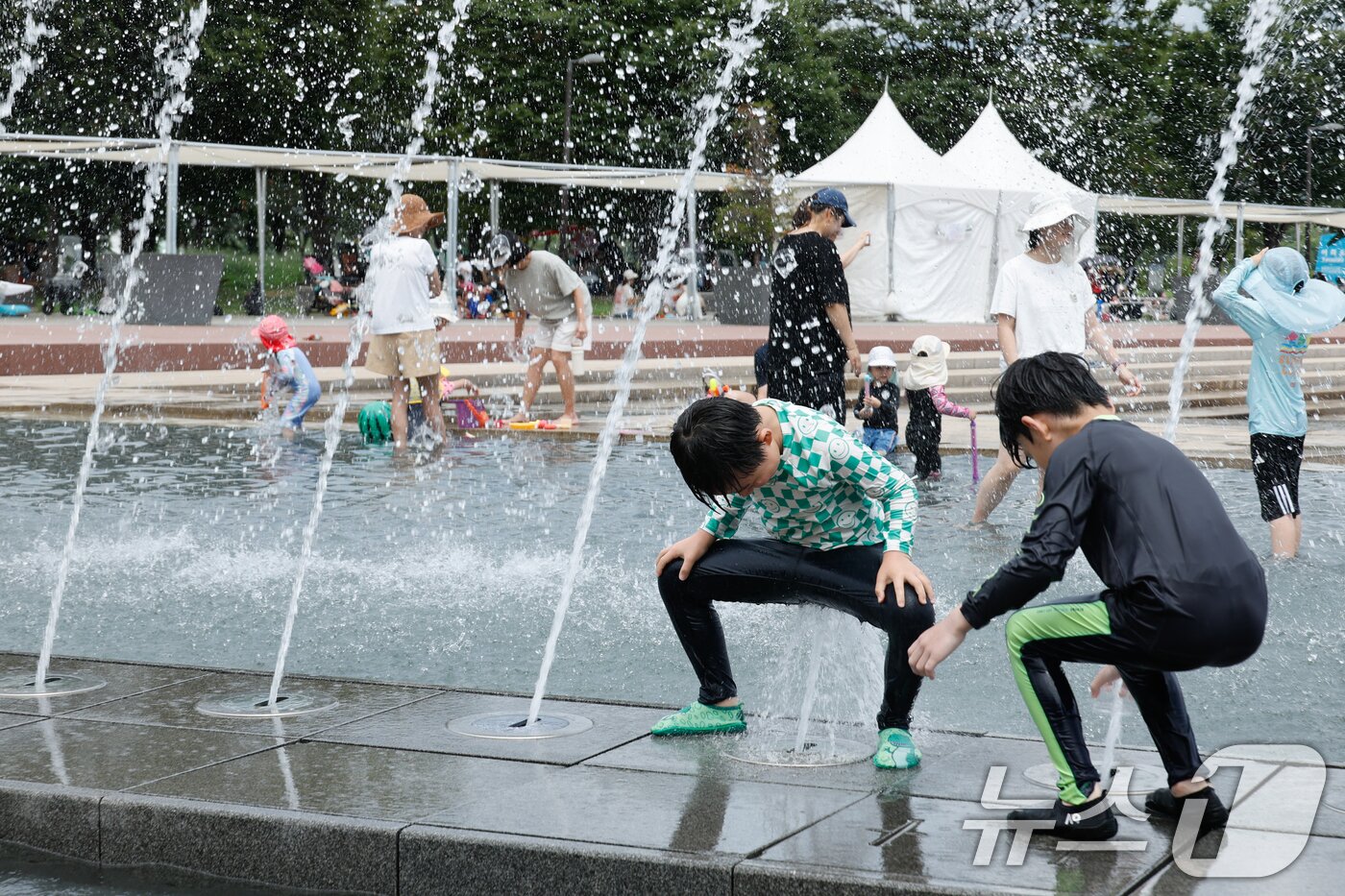 본문 이미지 - 광복절 연휴 마지막 날 무더위가 이어지고 있는 17일 오후 서울 여의도 한강공원 물빛광장을 찾은 어린이들이 물놀이를 즐기고 있다. 2025.8.17/뉴스1 ⓒ News1 안은나 기자