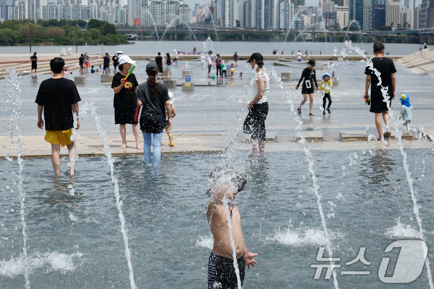 본문 이미지 - 광복절 연휴 마지막 날 무더위가 이어지고 있는 17일 오후 서울 여의도 한강공원 물빛광장을 찾은 어린이들이 물놀이를 즐기고 있다. 2025.8.17/뉴스1 ⓒ News1 안은나 기자