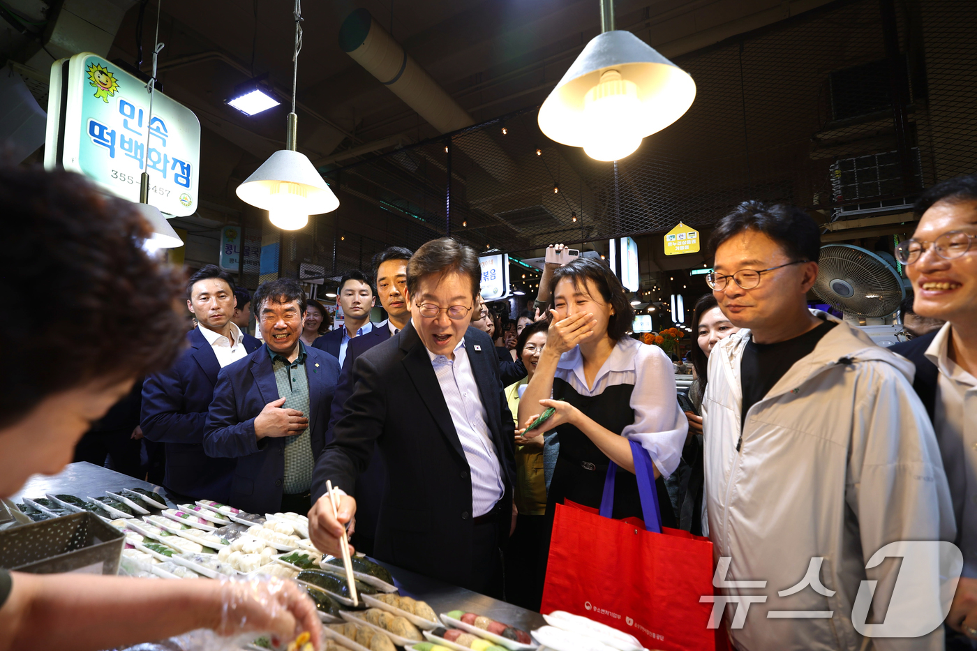 (서울=뉴스1) 허경 기자 = 이재명 대통령과 김혜경 여사가 17일 서울 은평구 연서시장을 방문해 떡을 시식하고 있다. (대통령실 제공. 재판매 및 DB 금지) 2025.8.17/ …