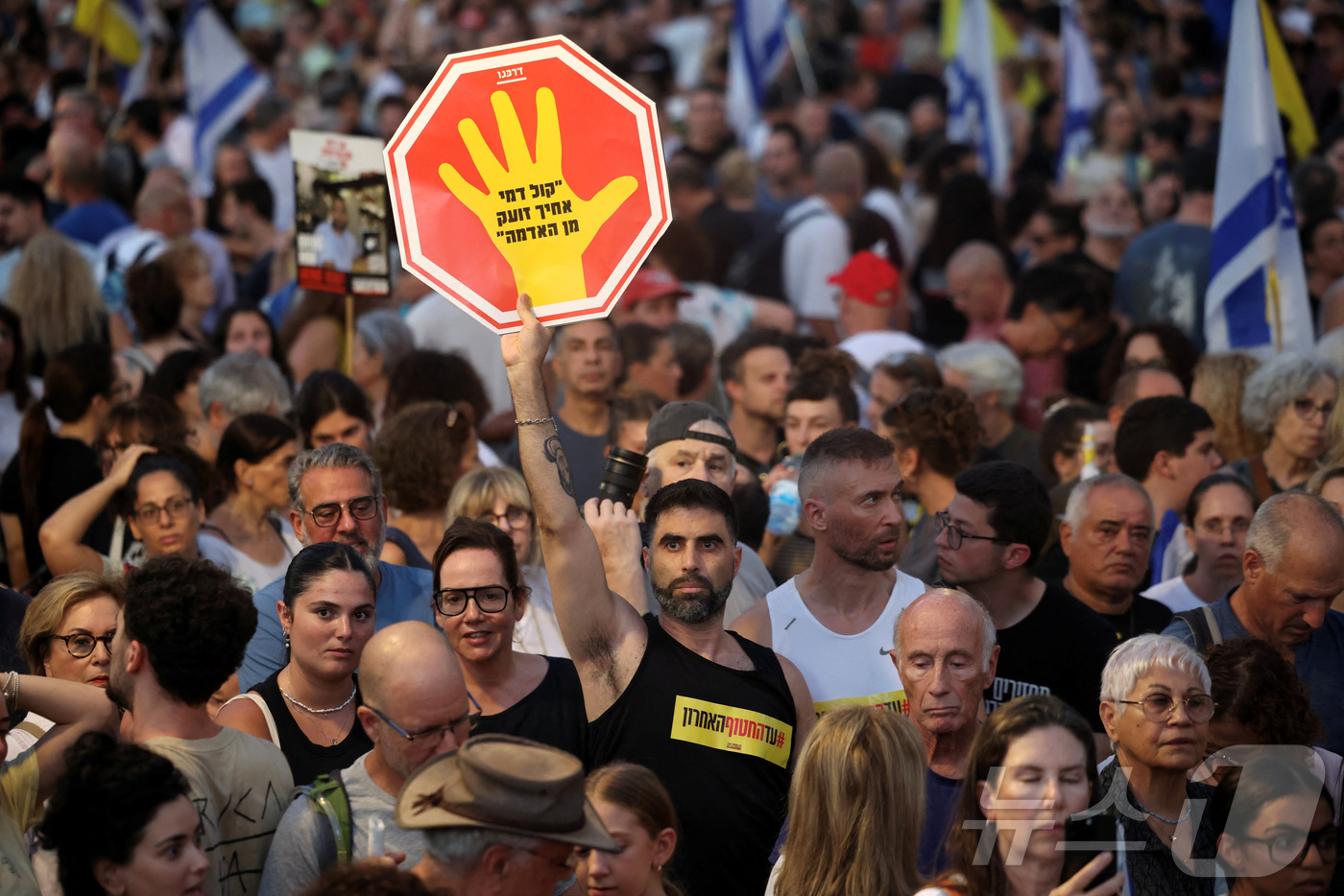 (텔아비브 로이터=뉴스1) 윤다정 기자 = 17일(현지시간) 이스라엘 텔아비브 '인질 광장' 일대에서 열린 인질 석방과 가자 전쟁 종식을 촉구하는 집회에서 한 참석자가 "네 아우의 …