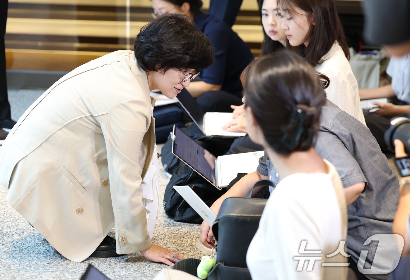 본문 이미지 - 원민경 여성가족부 장관 후보자가 18일 오전 서울 서대문구 한국청소년활동진흥원에 마련된 인사청문 준비 사무실로 첫 출근하며 취재진과 질의응답을 마친 후 바닥에 앉은 여기자들의 업무 환경을 살피며 대화하고 있다. 2025.8.18/뉴스1 ⓒ News1 오대일 기자