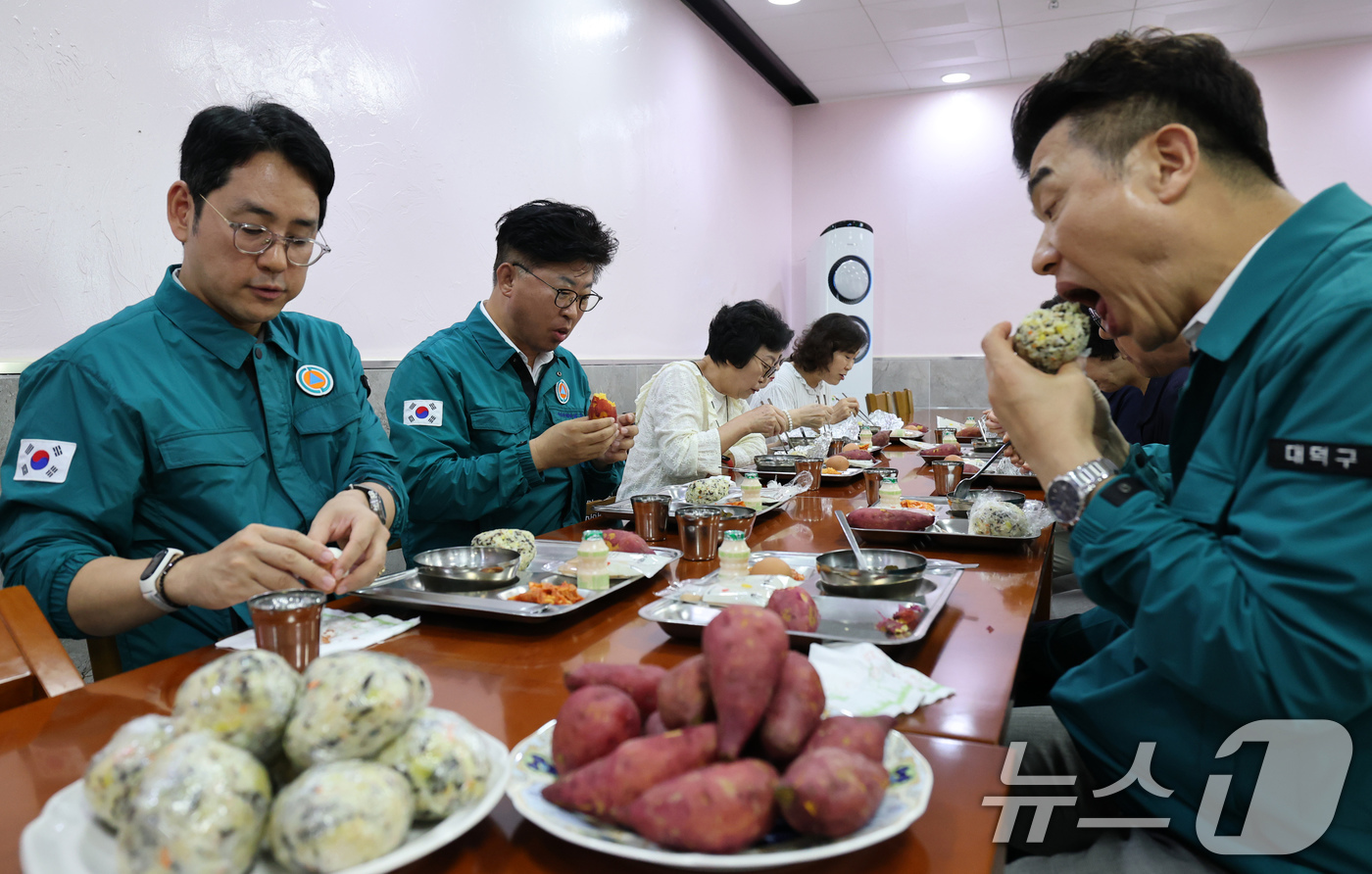 (대전=뉴스1) 김기태 기자 = 2025년 을지연습 첫날인 18일 대전 대덕구청 구내식당에서 최충규 구청장이 비상식량인 주먹밥과 고구마를 시식하고 있다.구는 이날 국가비상사태 시 …