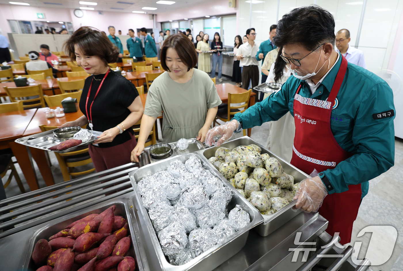 (대전=뉴스1) 김기태 기자 = 2025년 을지연습 첫날인 18일 대전 대덕구청 구내식당에서 최충규 구청장이 비상식량인 주먹밥과 고구마를 배식하고 있다.구는 이날 국가비상사태 시 …