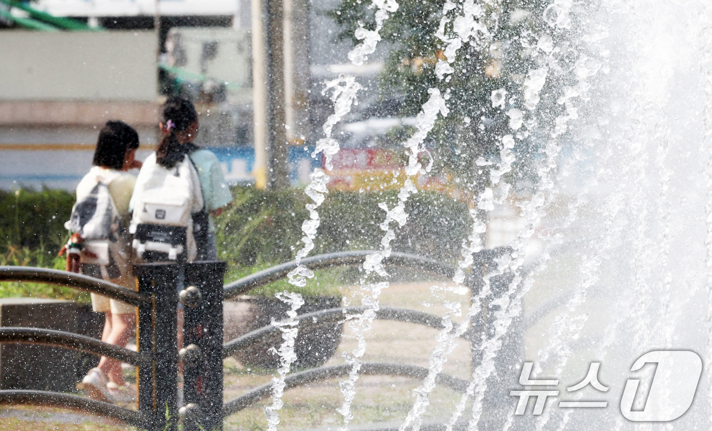 (오산=뉴스1) 김영운 기자 = 전국 대부분 지역에 폭염 경보나 주의보가 이어지고 있는 가운데 18일 오후 경기 오산시 수청공원에서 시민들이 시원하게 쏟아지는 폭포 앞으로 지나가고 …