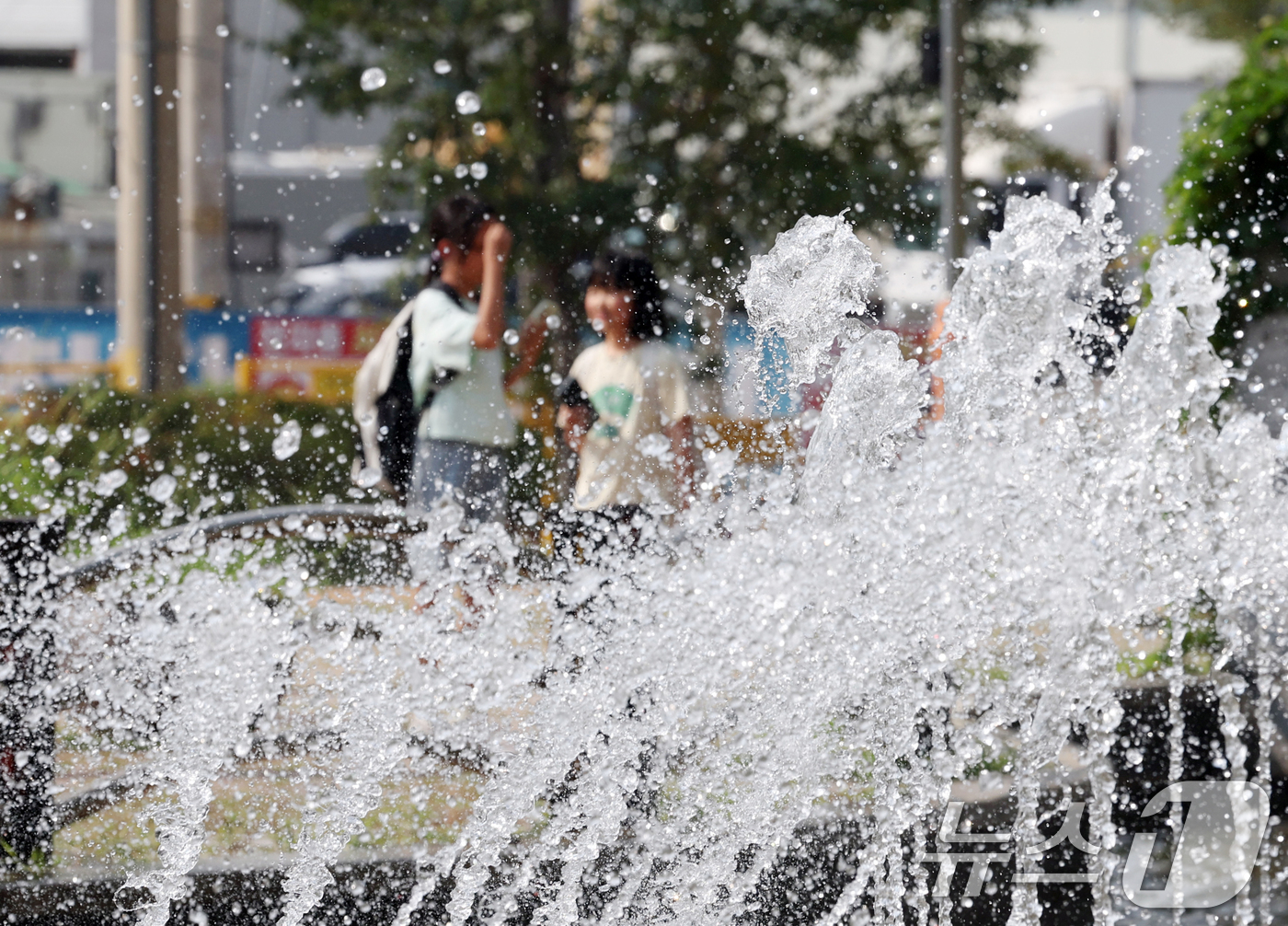 (오산=뉴스1) 김영운 기자 = 전국 대부분 지역에 폭염 경보나 주의보가 이어지고 있는 가운데 18일 오후 경기 오산시 수청공원에서 시민들이 시원하게 쏟아지는 폭포 앞으로 지나가고 …