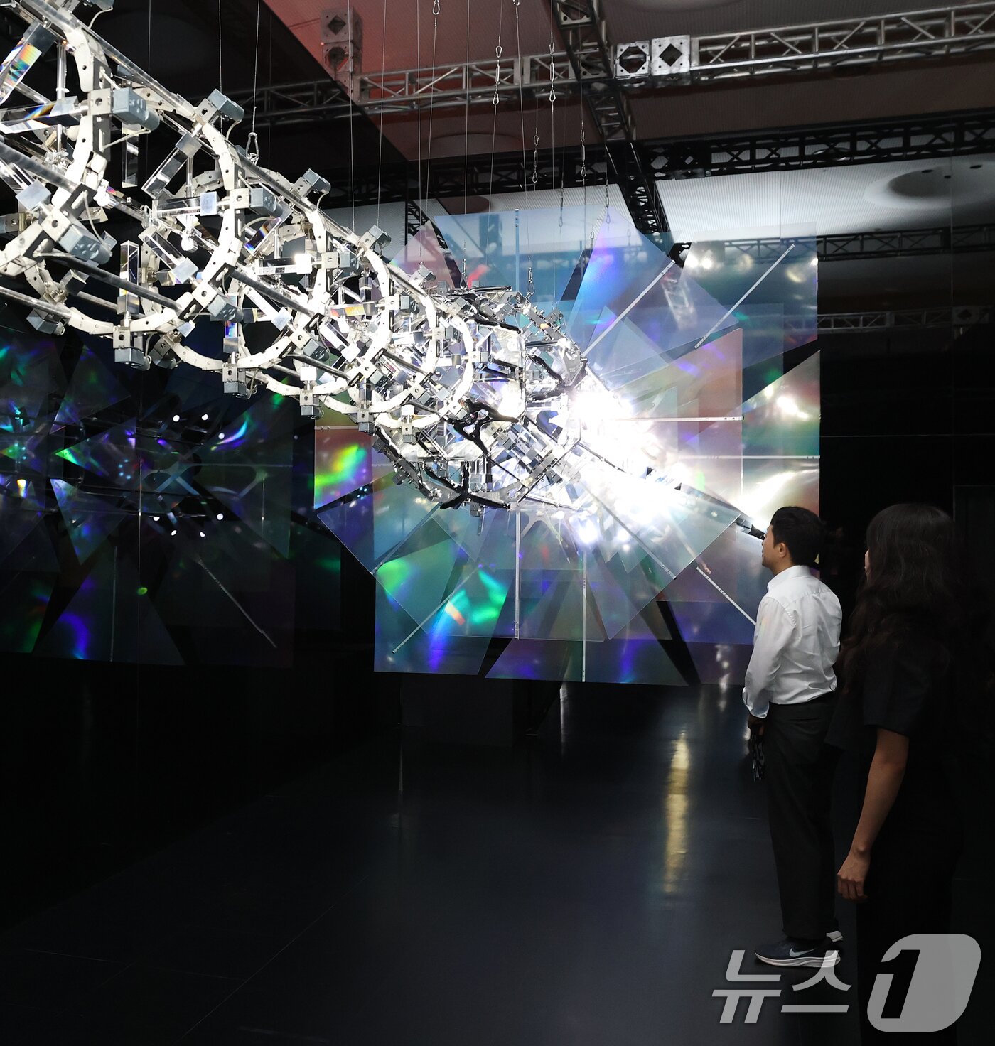 본문 이미지 - 19일 서울 동대문구 동대문디자인플라자(DDP)에서 열린 국가유산 활용 디지털 콘텐츠 전시 '헤리티지: 더 퓨처 판타지' 언론 공개회에서 방문객들이 한국의 탑을 빛과 움직임으로 재해석한 키네틱 아티스트 김준수의 '영원의 축'을 관람하고 았다.  2025.8.19/뉴스1 ⓒ News1 오대일 기자
