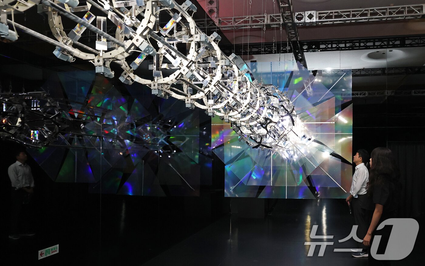 본문 이미지 - 19일 서울 동대문구 동대문디자인플라자(DDP)에서 열린 국가유산 활용 디지털 콘텐츠 전시 '헤리티지: 더 퓨처 판타지' 언론 공개회에서 방문객들이 한국의 탑을 빛과 움직임으로 재해석한 키네틱 아티스트 김준수의 '영원의 축'을 관람하고 았다. 2025.8.19/뉴스1 ⓒ News1 오대일 기자