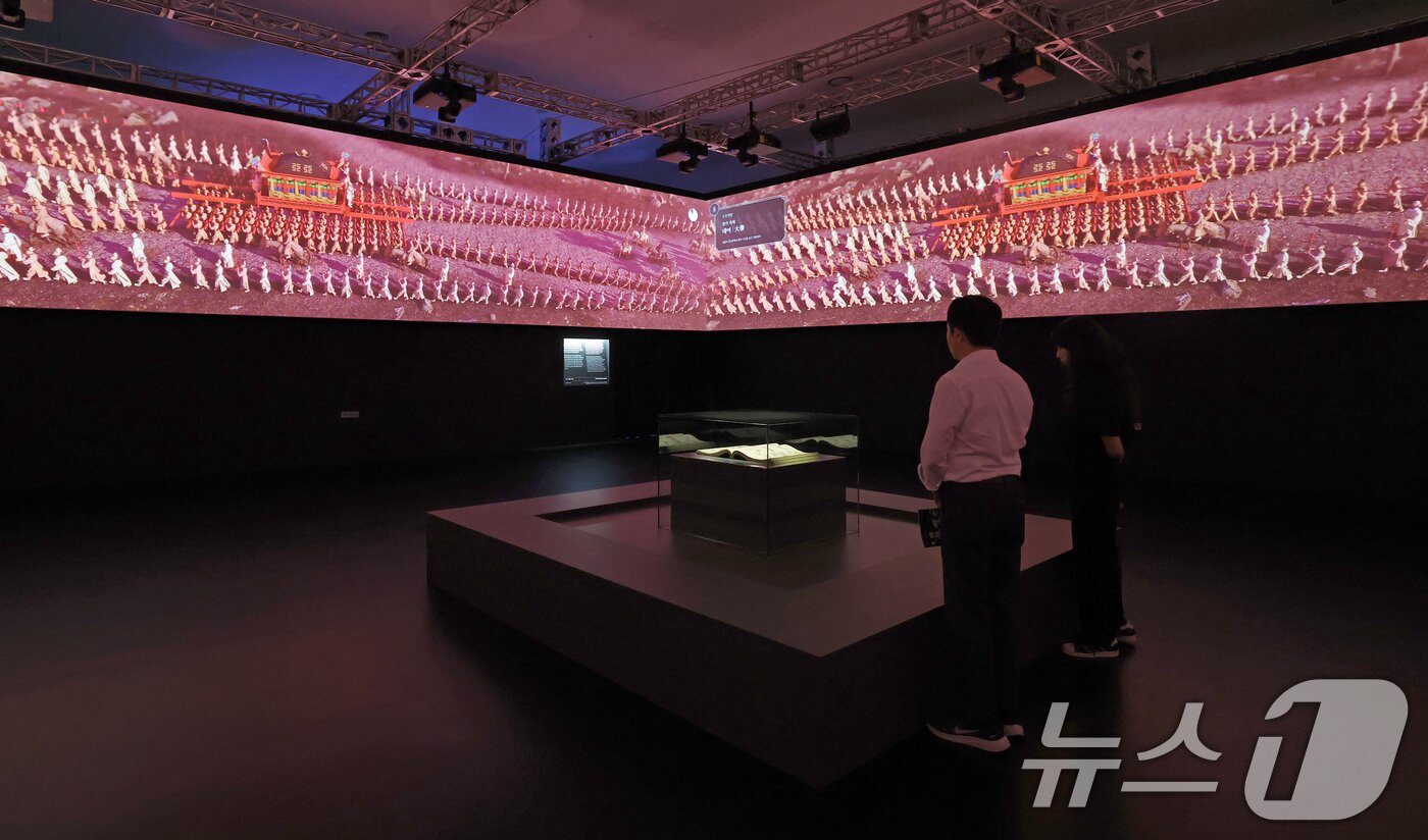 본문 이미지 - 19일 서울 동대문구 동대문디자인플라자(DDP)에서 열린 국가유산 활용 디지털 콘텐츠 전시 '헤리티지: 더 퓨처 판타지' 언론 공개회에서 방문객들이 조선왕조 의괘에 기록된 왕실 의례를 3D 미디어아트로 제작한 '의괘, 영원의 서사'를 관람하고 있다.  2025.8.19/뉴스1 ⓒ News1 오대일 기자